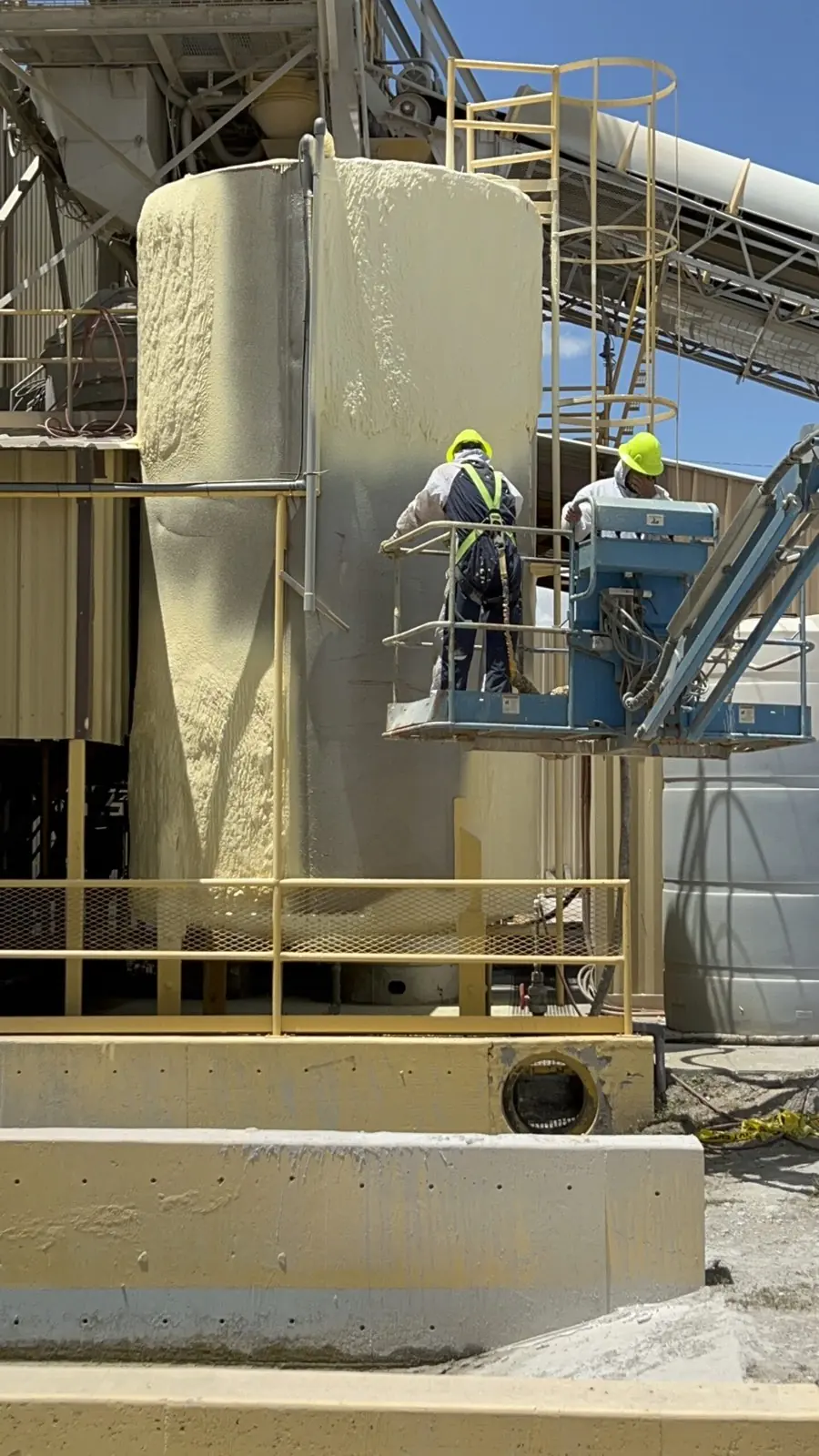 Panda Insulation crew applying spray foam to an industrial silo from a lift