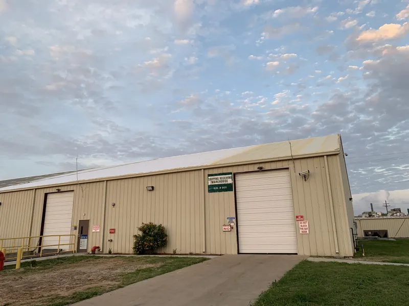 A tan metal commercial building with twin roll-up service doors, insulated and coated by Panda Insulation