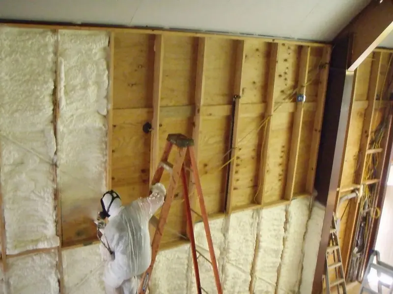 Panda Insulation technician spraying foam into an open wall cavity